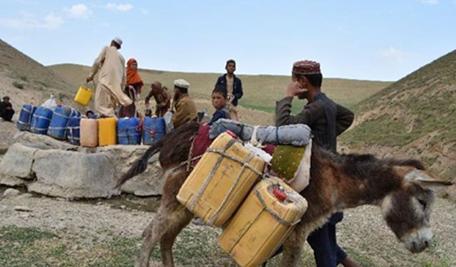 Afganistan'da bir kuyudan su almak için bekleyen köylüler