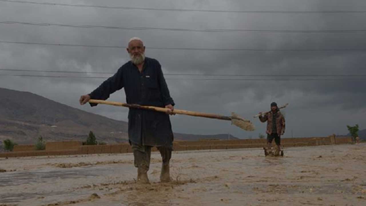 Afgan-erkekler-şiddetli-yağmur-nedeniyle-hasar-gören-evlerin-dışında-çalışıyor
