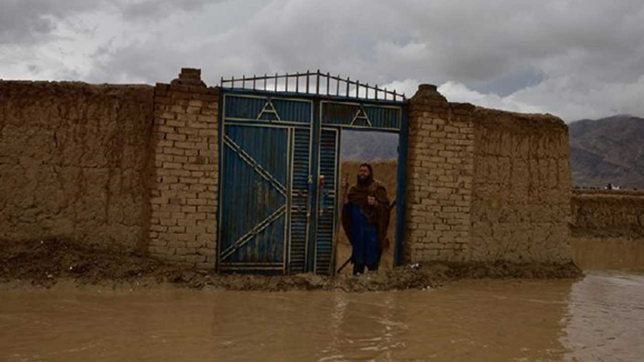 Afgan,-şiddetli-yağmur-sonrasında-bir-evin-kapısında-duruyor