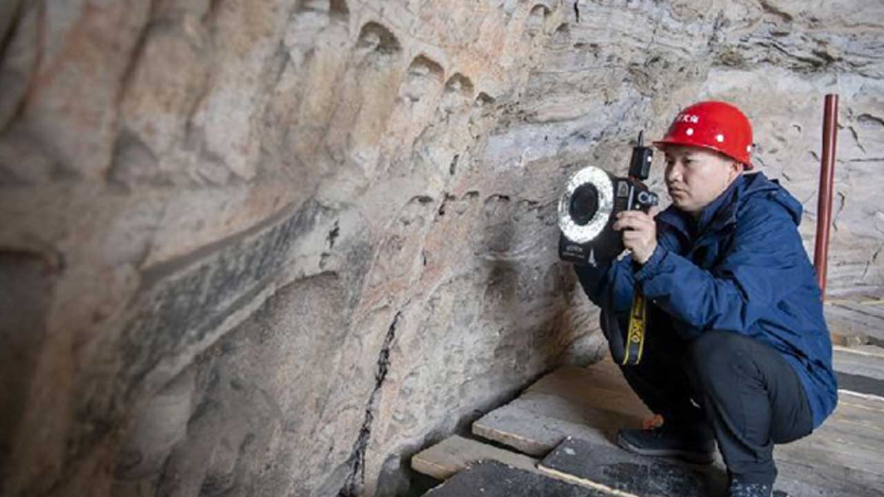 Shanxi-eyaletinde-bulunan-Datong'daki-Yungang-Mağaraları'nda-bir-teknisyen-Mağara-17'deki-kalıntılarla-ilgili-veri-topluyor