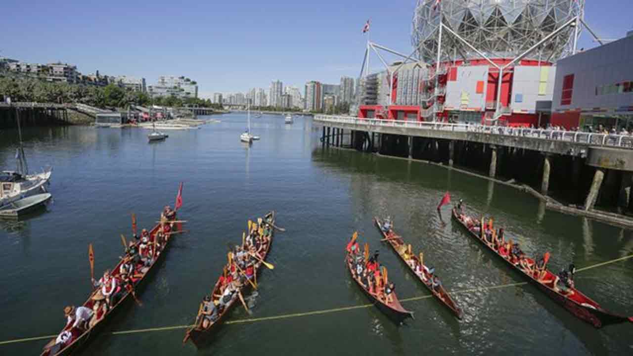 British-Columbia-eyaletinde-yer-alan-Vancouver'daki-bir-kano-geçit-töreninde-Bilim-Dünyası'nın-önünden-geçen-yerli-kanolar,-14-Temmuz-2022