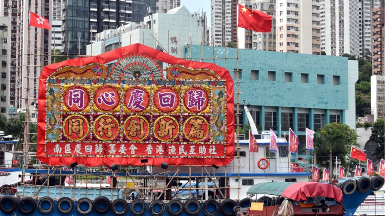 Çin'in güneyindeki Hong Kong'da Çin ulusal bayrağı ile Hong Kong Özel İdari Bölgesi'nin (HKSAR) bayraklarını taşıyan, çiçeklerle donatılmış bir balıkçı teknesi görülüyor, 30 Haziran 2022.(Fotoğraf Lo Ping FaiX