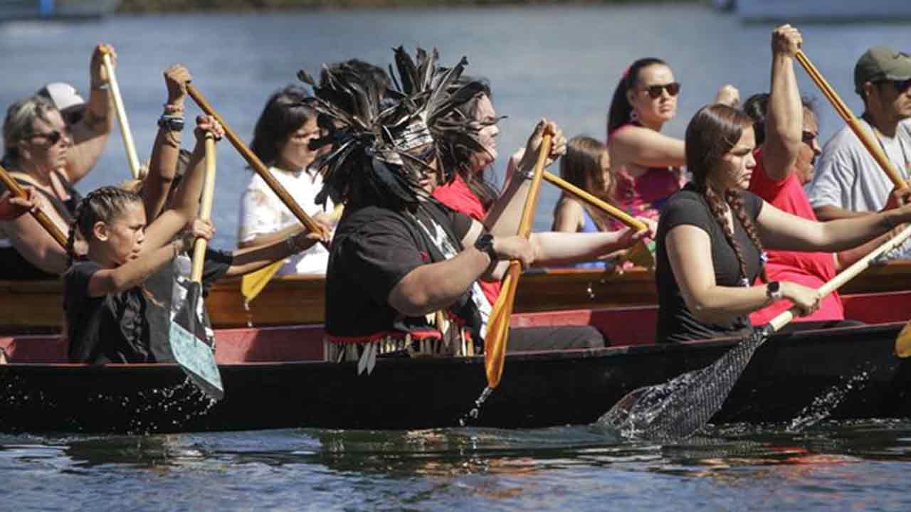 Vancouver'daki-False-Creek'te-bir-kano-geçit-töreni-sırasında-kürek-çeken-yerli-halk,